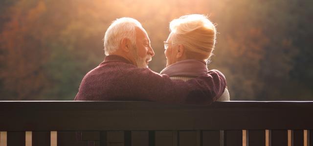 Senior Couple Sitting on Bench in Autumn Park